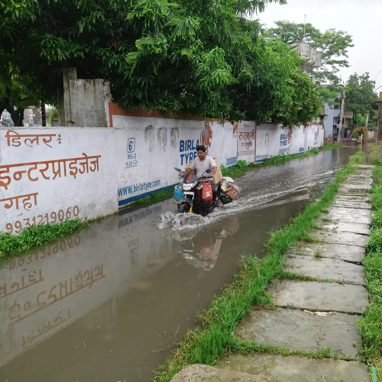 सड़क पर जल जमाव होने से मजबूरन पार करते राहगीर