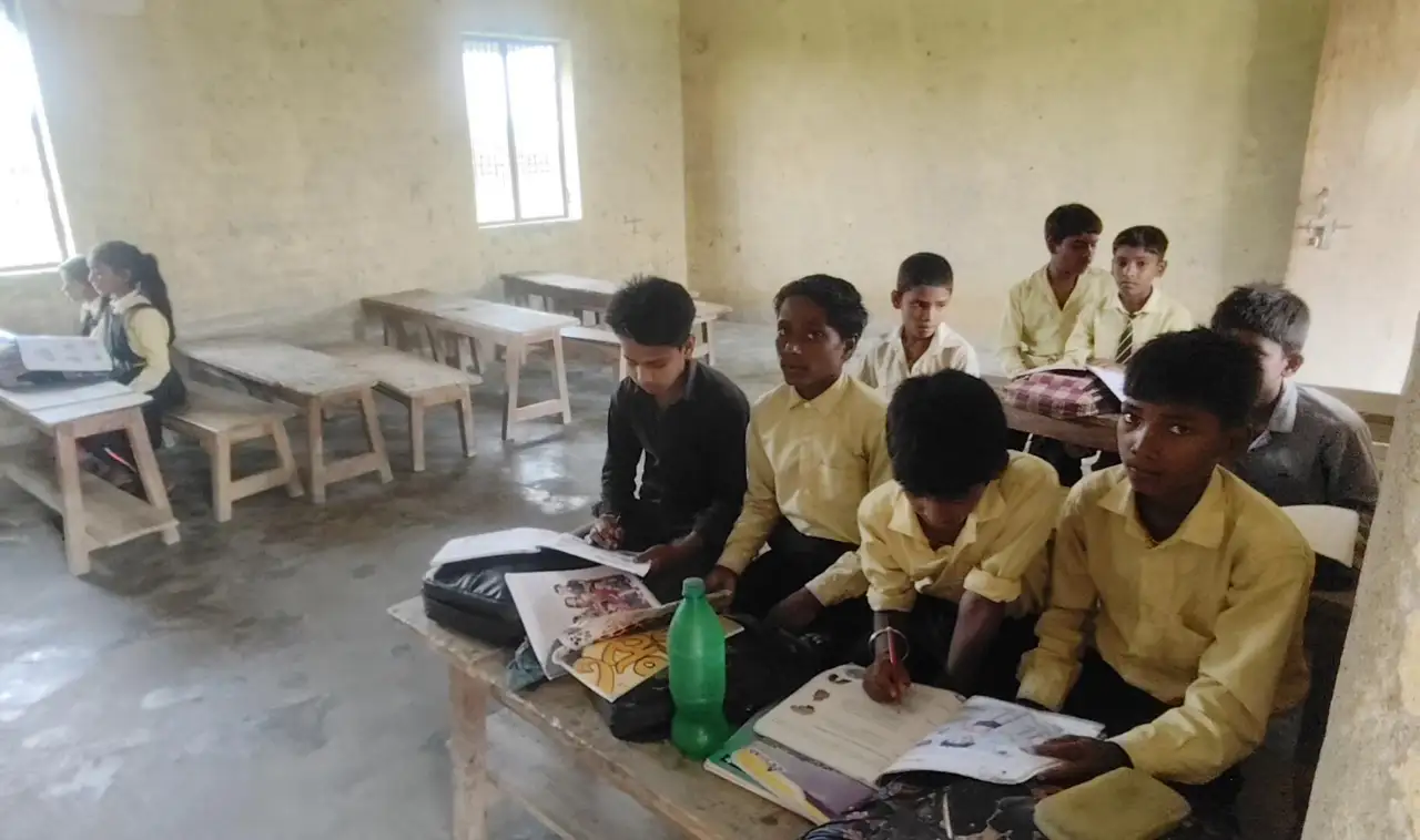स्कूल में क्लास में पढ़ाई करते बच्चे