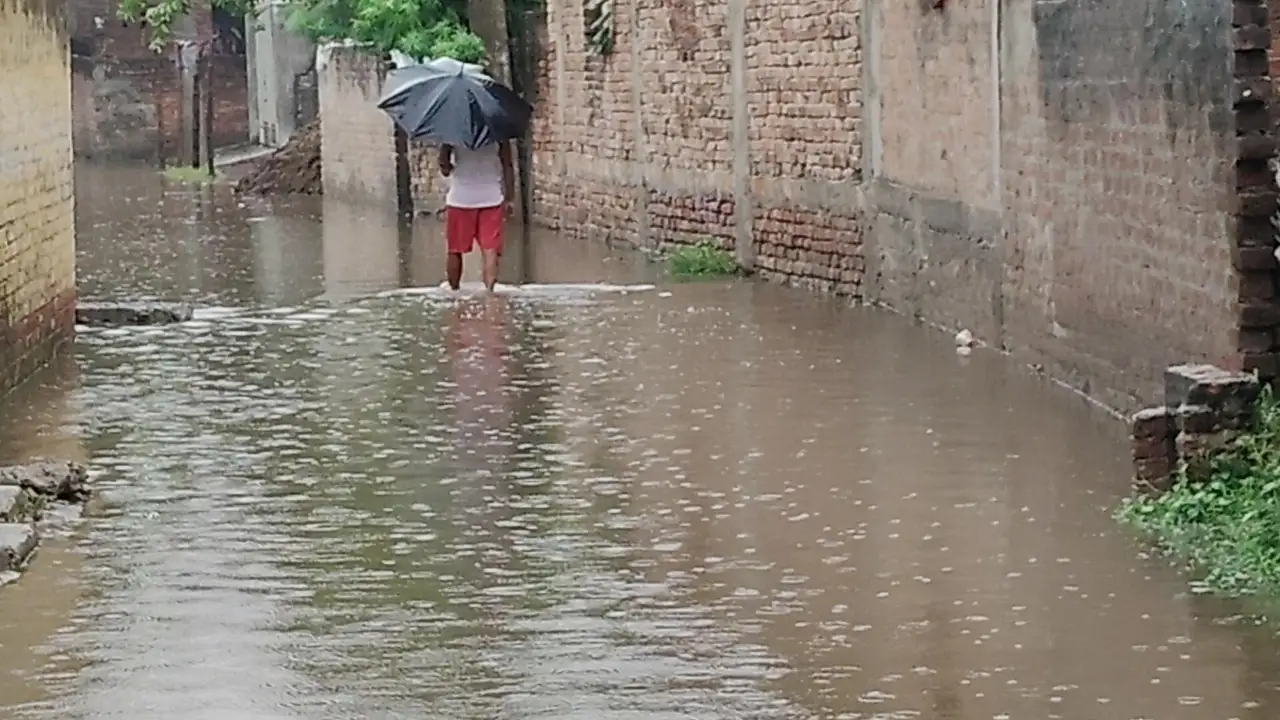 जलजमाव के बीच जान जोखिम में डालकर गुजरते राहगीर
