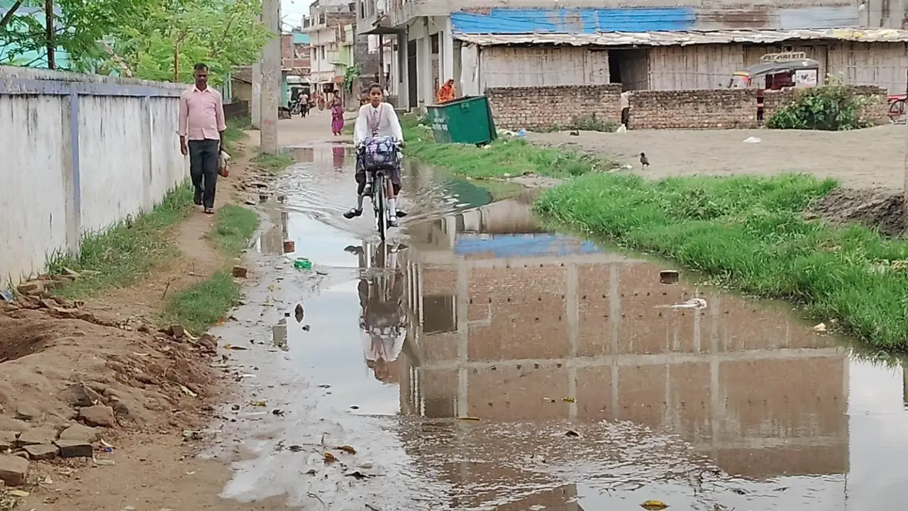 सड़क पर जलजमाव से राहगीरों की बढ़ी परेशानी, गंदे पानी से होकर गुजरने को मजबूर लोग