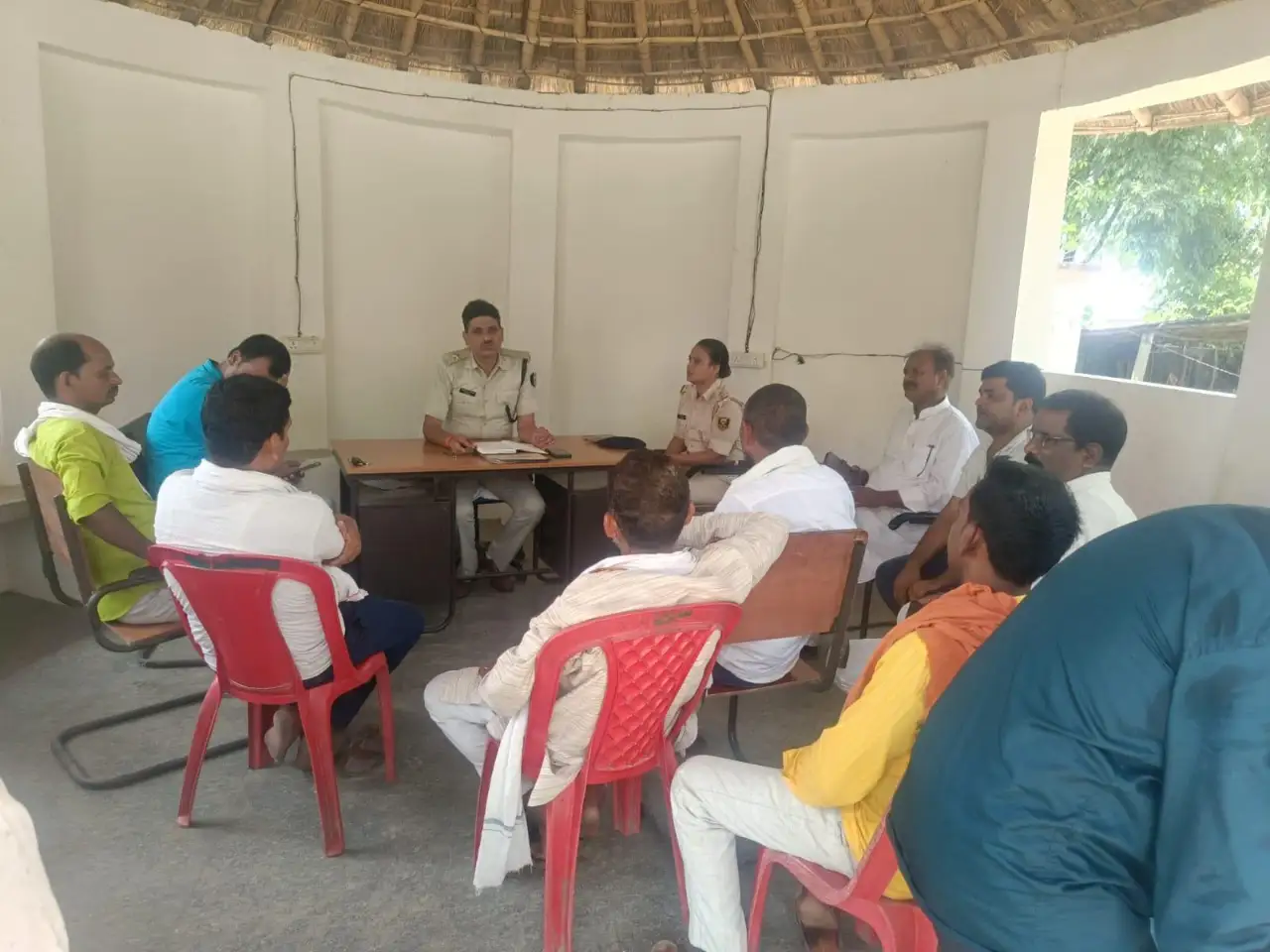 धनहा थाना परिसर में बैठक करते थानाध्यक्ष