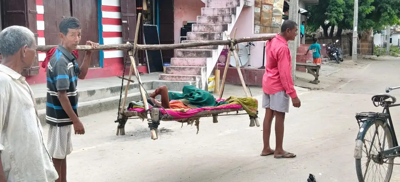 खाट पर मरीज, बदहाल सड़कें बनीं इलाज की राह में बाधा